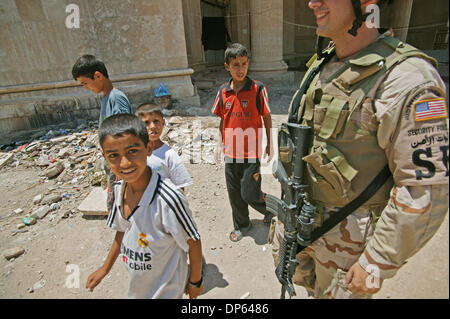 Ott 06 2006, Baghdad, Iraq; ragazzi iracheno camminare al fianco di Airman Prima Classe Brad Birkbeck di Baghdad IZ della polizia sui motivi di Saddam Hussein in ex teatro a Baghdad. Diverse famiglie irachene, spostato dopo il 2003 invasione, cercato rifugio nei resti di Saddam Hussein teatro personali, costruito per intrattenere l'ex presidente iracheno durante la sua regola. Le famiglie di paura Foto Stock