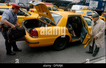 Oct 25, 2006; MANHATTAN, NEW YORK, Stati Uniti d'America; una coppia di anziani è assistita in un taxi da un portiere a New York's Penn Station come il New York City Taxi e Limousine la Commissione annuncia un aumento nel costo di 'tempo di attesa' da 20 centesimi al minuto a 40 centesimi al minuto. L'aumento per le cabine bloccati nel traffico dovrebbe aumentare il costo di una corsa da $1, è il primo 'in attesa' Foto Stock