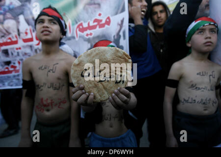 Rafah nella striscia di Gaza . 8 Gen, 2014. Bambini palestinesi prendere parte ad una manifestazione di solidarietà con i profughi palestinesi in Siria la principale campo profughi Yarmouk. Le parole arabe sul pane leggere, ''Io Sono affamato''. © Eyad Al Baba APA/images/ZUMAPRESS.com/Alamy Live News Foto Stock