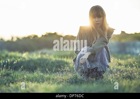 Moda giovane ragazza accovacciato in abito a strapiombo e giacca Foto Stock