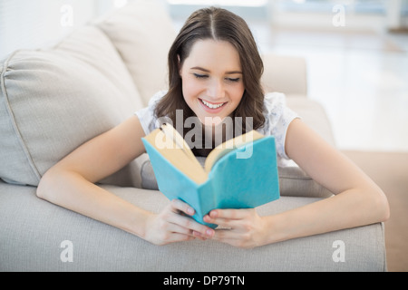 Tranquilla bella donna sdraiata su un confortevole lettino libro di lettura Foto Stock