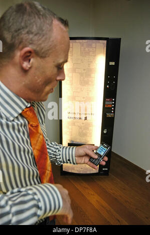 14 nov 2006; Kista, Svezia; un tour attraverso la Ericsson World Headquarters Building a Kista. Nella foto, un Ericsson acquista esecutivo di una lattina di soda da un distributore automatico nella hall. Le bibite sono gratuite e il distributore è lì a dimostrare un nuovo modo i prodotti possono essere venduti tramite i telefoni cellulari. In questo caso il compratore invia un semplice messaggio di testo, out compare anche la soda e il pric Foto Stock