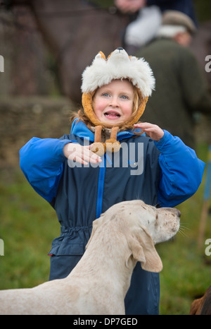 A hound sembra assumere un interesse in un copricapo di un giovane seguace di suoneria in occasione di una riunione del Beaufort Hunt in Didmarton, Glo Foto Stock