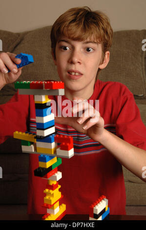 Nov 17, 2006; Lawrenceville, GA, Stati Uniti d'America; i giovani disabili intellettivi e relazionali MATTHEW Bennett, 8, con l'apprendimento disabilità gioca con pezzi di lego per costruire la torre e di aumentare la sua capacità di attenzione. Credito: Foto di Robin Nelson/ZUMA premere. (©) copyright 2006 di Robin Nelson Foto Stock