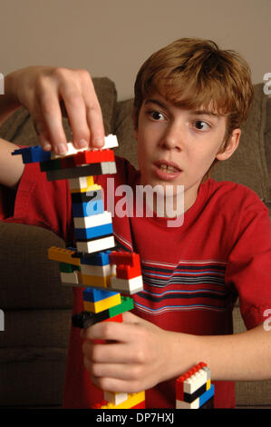 Nov 17, 2006; Lawrenceville, GA, Stati Uniti d'America; i giovani disabili intellettivi e relazionali MATTHEW Bennett, 8, con l'apprendimento disabilità gioca con pezzi di lego per costruire la torre e di aumentare la sua capacità di attenzione. Credito: Foto di Robin Nelson/ZUMA premere. (©) copyright 2006 di Robin Nelson Foto Stock