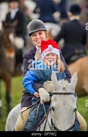 Un cavallo Cavaliere dà a sua figlia una corsa a un incontro natalizio del Beaufort Hunt in Didmarton, GLOUCESTERSHIRE REGNO UNITO il sabato Foto Stock