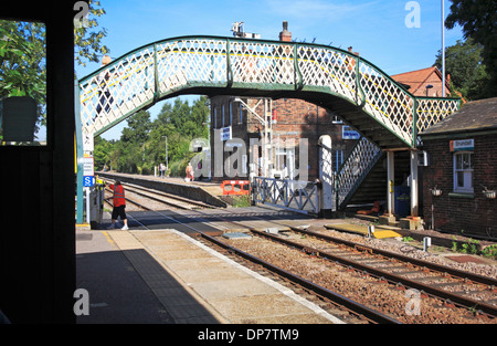 Una vista della stazione ferroviaria con un ponte pedonale e il passaggio a livello Brundall, Norfolk, Inghilterra, Regno Unito. Foto Stock