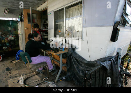 Nov 09, 2006; Chula Vista, CA, Stati Uniti d'America; al Rose Arbor Mobile Home Park in Chula Vista, EVA LOPEZ lavora da casa come ella cuce e rende le alterazioni di vestiti. Lopez insieme a suo marito meno Sandoval ha acquistato la casa del rimorchio 3 anni fa e ora la loro casa con i loro 3 figli (twin ragazze età15 e un figlio, meno Sandoval 8 anni). Credito: Foto di Nelvin C. Foto Stock