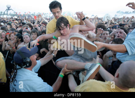 Apr 28, 2006 - Indio , CA, Stati Uniti d'America - con temperature oltre i 100 gradi, questo ventilatore è aiutato fuori della buca sul Coachella stadio dopo il Re di Leon giocato con l aiuto della sicurezza che ha tirato le persone che erano troppo caldi o in frantumi il sabato a Coachella il festival annuale di musica. (Credito Immagine: © Sean Haffey/San Diego Union Tribune/ZUMA Premere) Restrizioni: la e arancione Foto Stock