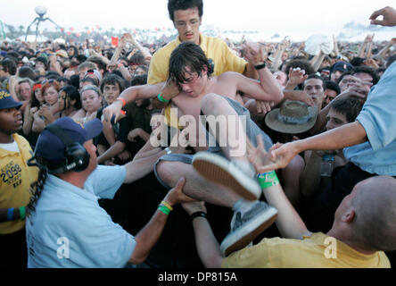 Apr 28, 2006 - Indio , CA, Stati Uniti d'America - con temperature oltre i 100 gradi, questo ventilatore è aiutato fuori della buca sul Coachella stadio dopo il Re di Leon giocato con l aiuto della sicurezza che ha tirato le persone che erano troppo caldi o in frantumi il sabato a Coachella il festival annuale di musica. (Credito Immagine: © Sean Haffey/San Diego Union Tribune/ZUMA Premere) Restrizioni: la e arancione Foto Stock