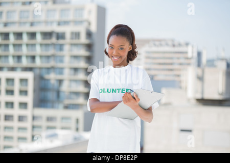 Sorridente donna volontariato holding negli appunti Foto Stock