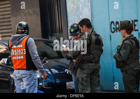 Caracas, Venezuela. 8 Gen, 2014. Un soldato controlla una persona di documento in Caracas, la capitale del Venezuela, 8 gennaio, 2014. Oltre 5 mila vittime sono state registrate in 2013 a Caracas, rendendo il Venezuela uno dei paesi con il più alto tasso di violenza e di criminalità. Credito: Boris Vergara/Xinhua/Alamy Live News Foto Stock