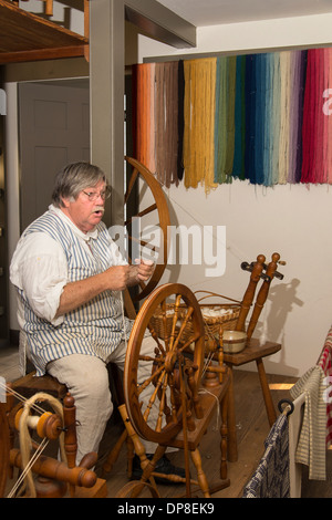 Williamsburg Coloniale artigiano dimostra una filatura coloniale ruota utilizzata per rendere il thread per prodotti tessili Foto Stock
