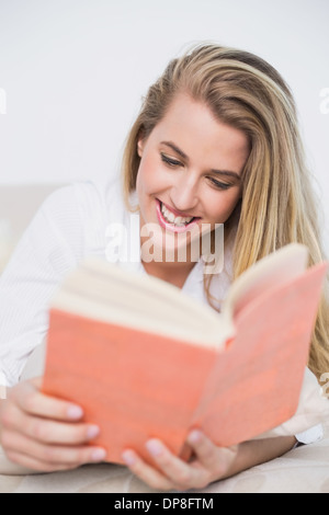 Splendido modello giacente sul letto confortevole lettura prenota Foto Stock