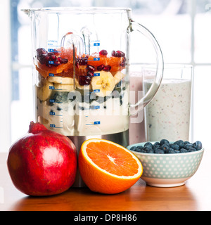 Preparate i frullati e frullato sano gli ingredienti nel frullatore con frutta fresca pronta per la miscela sul tavolo da cucina Foto Stock