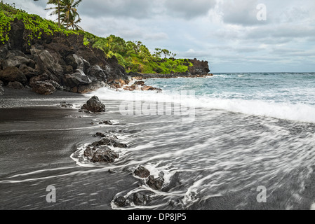 L'esotico e famosa spiaggia di sabbia nera di Waianapanapa State Park in Maui, Hawaii. Foto Stock