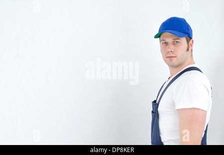 Tradesman in uniforme in piedi vicino alla parete. Spazio per il testo. Foto Stock