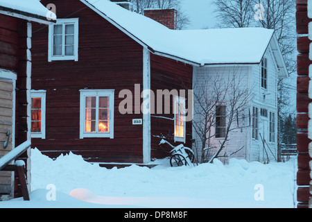 Casa in legno rosso con sensazione di Natale in inverno nordico con la neve Foto Stock