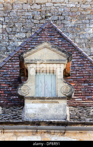 Domme, Dordogne, la Francia, l'Europa. Inusuale finestra sul tetto di un vecchio edificio tradizionale. Foto Stock