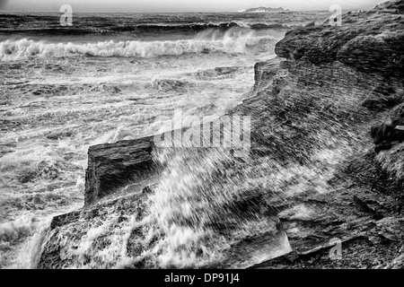 Le onde che si infrangono sulle rocce durante una tempesta, Harlyn Bay, a Padstow, Cornwall, Inghilterra Foto Stock