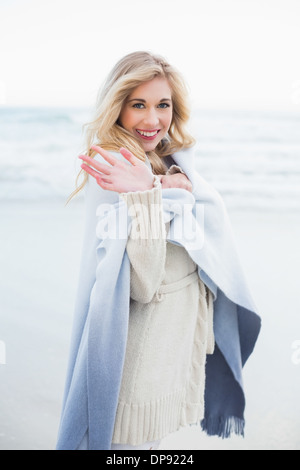 Felice donna bionda in una coperta sventolando la fotocamera A Foto Stock