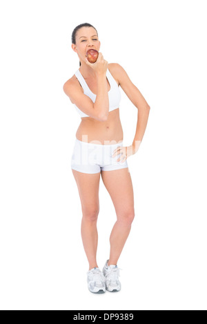 Donna felice di indossare abbigliamento sportivo mangiare apple Foto Stock