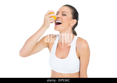 Sorridente donna sportiva di bere succo di arancia Foto Stock