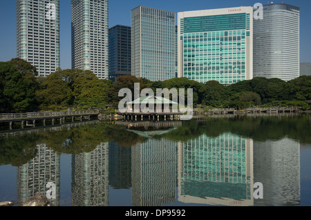 Nakajima Tea House tra le riflessioni di Shiodome skyline nel laghetto Shioiri, Hama Rikyu Teien (Hamarikyu giardino separato), Tokyo, Giappone Foto Stock