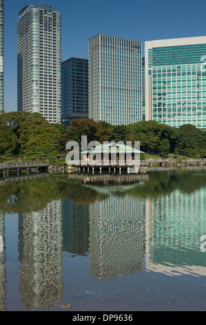 Nakajima Tea House tra le riflessioni di Shiodome skyline nel laghetto Shioiri, Hama Rikyu Teien (Hamarikyu giardino separato), Tokyo, Giappone Foto Stock