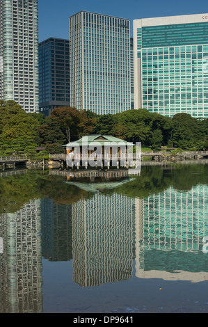 Nakajima Tea House tra le riflessioni di Shiodome skyline nel laghetto Shioiri, Hama Rikyu Teien (Hamarikyu giardino separato), Tokyo, Giappone Foto Stock