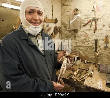 Burbank, in California, Stati Uniti d'America. Il 9 gennaio, 2014. Un quasi statuetta finito nelle mani di master di finitura metallica Servando Santa Maria di giovedì mattina. Santa Maria dice che impiega circa 2 ore per strumento completamente e pulire la statuetta, tra cui una bella finitura brunita pronti per applicare la finale di finitura verdigris.--------esperti artigiani ha portato dal maestro fondatore Enrique Guerrero presso la American Fine Arts Fonderia di Burbank versata alcune delle ultime statuette di premio per questo anni Screen Actors Guild Awards che si terrà il 18 gennaio 2014. Credito: ZUMA Press, Inc./Alamy Live News Foto Stock