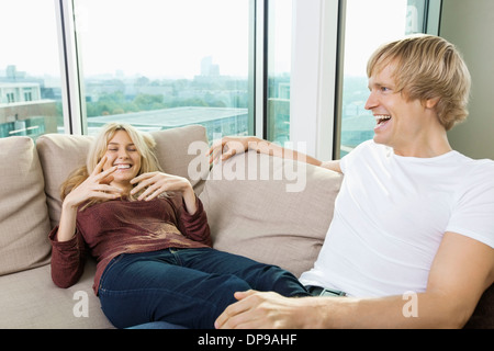 Allegro giovane rilassante sul divano di casa Foto Stock