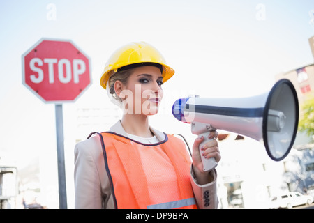 Grave imprenditrice indossando abiti costruttori holding megafono Foto Stock