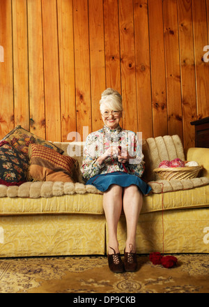 Ritratto di felice senior Maglieria donna sul divano di casa Foto Stock