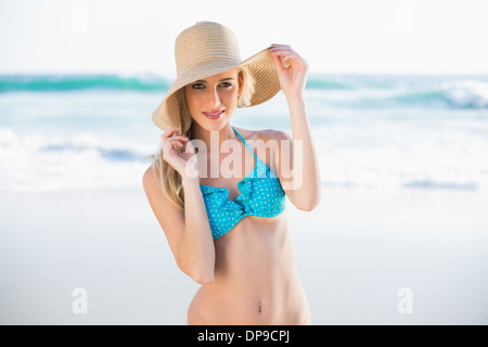 Allegro una splendida bionda in bikini indossando cappello di paglia Foto Stock