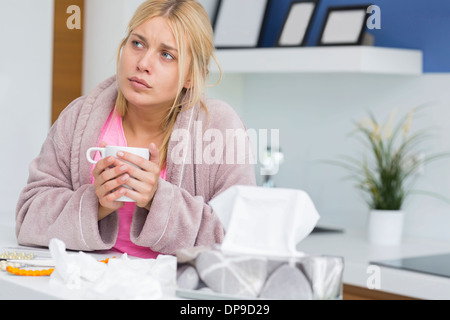 Giovane donna soffrono di freddo azienda tazza da caffè Foto Stock