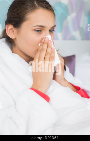 Giovane donna che soffre di soffiaggio aria fredda naso in camera da letto Foto Stock