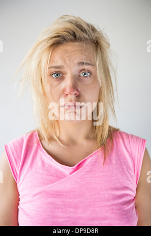 Ritratto di donna triste soffrono di freddo contro uno sfondo grigio Foto Stock