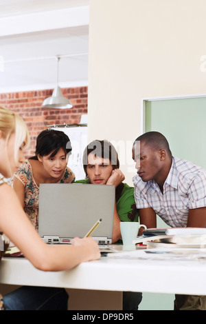 Quattro persone aventi riuniti attorno al computer. Foto Stock