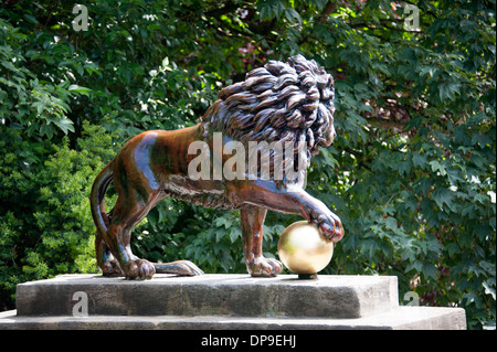 Leone di Bronzo con zampa piede sul globo a sfera gold Foto Stock