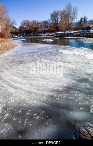 Neve e ghiaccio soffocato Arkansas River, che corre attraverso il quartiere del centro storico del piccolo paese di montagna di salida, CO Foto Stock