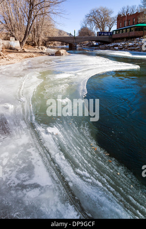 Neve e ghiaccio soffocato Arkansas River, che corre attraverso il quartiere del centro storico del piccolo paese di montagna di salida, CO Foto Stock