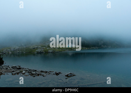 Basse nubi oltre il rifugio dal Lac de Gaube nella Vallée de Gaube nei Pirenei francesi Foto Stock