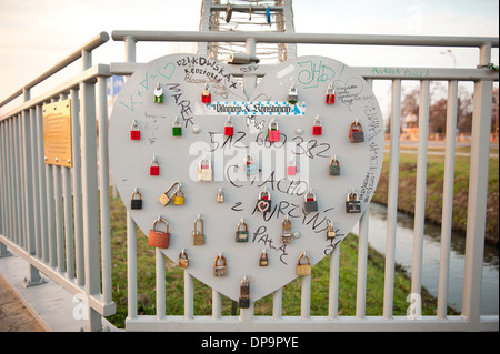 Alla moda di amore i lucchetti sul cuore di metallo sul ponte Foto Stock