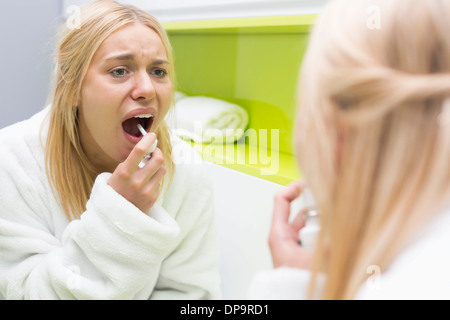 La riflessione della donna medicina di spruzzatura in bocca Foto Stock