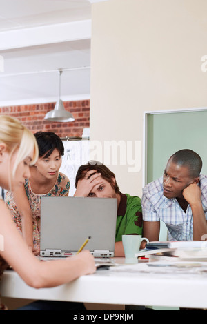 Quattro persone aventi riuniti attorno al computer. Foto Stock