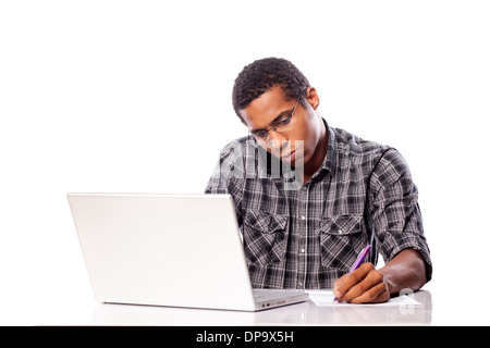 Grave giovane uomo nero scrive i dati dal suo computer portatile Foto Stock