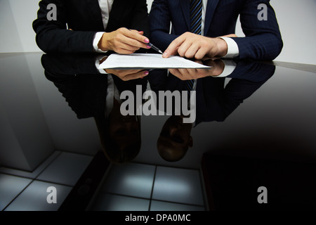 Immagine di mani umane durante la lettura del contratto Foto Stock