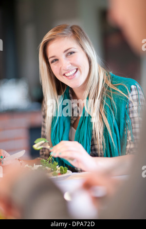 Giovane donna di mangiare insalata in cucina Foto Stock