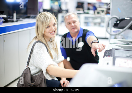 Giovane donna e venditore in showroom Foto Stock